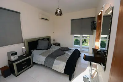 a bedroom with a bed and a desk and a mirror at Karythia in Pyla