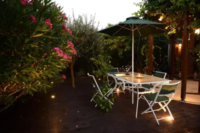 a table and chairs with an umbrella on a patio at Karythia in Pyla