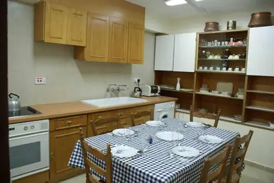 a kitchen with a table with a checkered table cloth at Yiayia's House Limassol city in Limassol