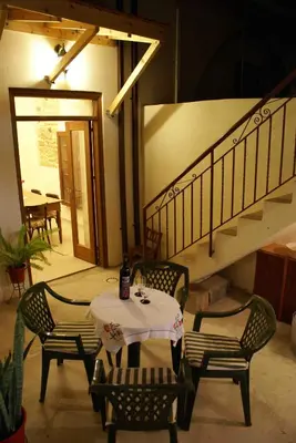 a table and chairs in a room with a staircase at Yiayia's House Limassol city in Limassol