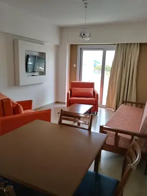 a living room with couches and a table and chairs at Livas Hotel Apartments in Protaras