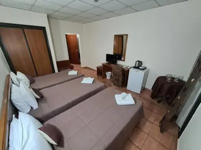 a hotel room with two beds and a television at Metropole Hotel in Limassol