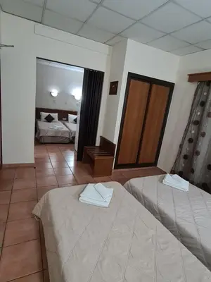 a hotel room with two beds and a mirror at Metropole Hotel in Limassol