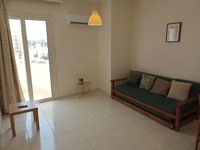 a living room with a green couch and a window at Mandalena Hotel Apartments in Protaras