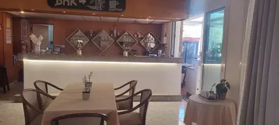 a dining room with two tables and a bar at Mandalena Hotel Apartments in Protaras