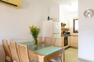 a kitchen with a table and chairs and a refrigerator at Tranquil Kyklades BC6, WALK to BEACH in Paralimni