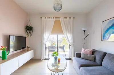 a living room with a couch and a tv at Tranquil Kyklades BC6, WALK to BEACH in Paralimni