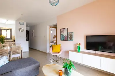 a living room with a couch and a tv at Tranquil Kyklades BC6, WALK to BEACH in Paralimni
