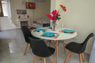 a dining room table with chairs and a vase of flowers at Villa Elena in Ayia Napa