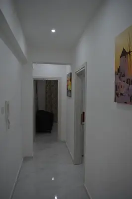 a hallway with white walls and a white floor at P.L Hermes Studios & Apartments in Larnaka