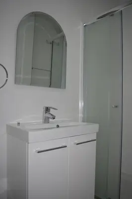 a white bathroom with a sink and a mirror at P.L Hermes Studios & Apartments in Larnaka
