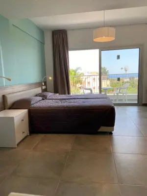 a bedroom with a bed and a view of a balcony at Sweet Memories Hotel Apts in Protaras