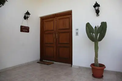 a cactus in a pot next to a wooden door at Residence L' Aubrais in Limassol