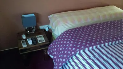 a bedroom with a bed and a nightstand with a phone at Residence L' Aubrais in Limassol
