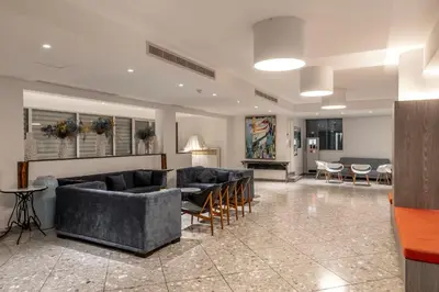 a living room with couches and tables and chairs at Park Beach Hotel in Limassol