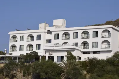a white building with trees in front of it at E.J. Pyrgos Bay Hotel in Kato Pyrgos