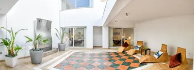a living room with chairs and a checkered floor at Villa Nausica in Protaras