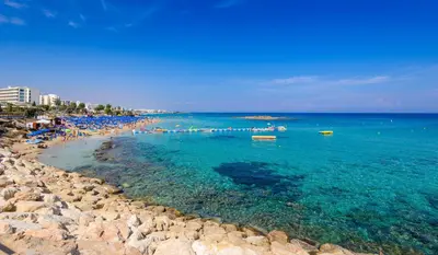 a beach with a group of people in the water at Villa Nausica in Protaras