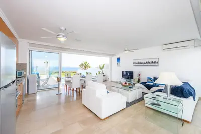 a living room with white furniture and a view of the ocean at Villa Nausica in Protaras