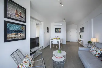 a living room with a couch and a tv at Mackenzie Zoe Seafront Suite in Larnaka
