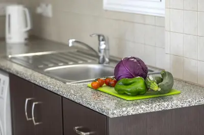 a plate of vegetables on a counter next to a sink at Protaras Palm Suite in Protaras