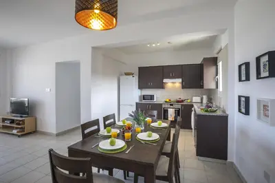 a dining room and kitchen with a table and chairs at Protaras Palm Suite in Protaras