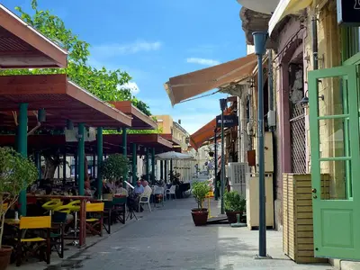 a street with tables and chairs and people sitting at tables at Poseidon Boutique Apartment 1 in Limassol