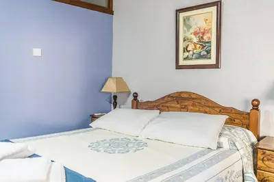 a bedroom with a bed and a picture on the wall at To Konatzi tou Flokka in Ayios Theodhoros