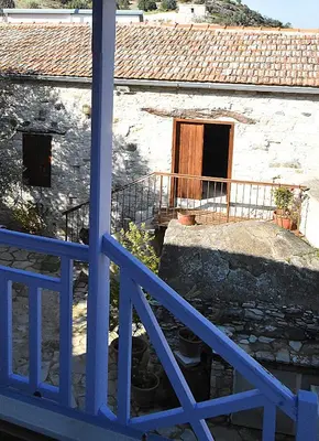 a blue fence in front of a stone building at To Konatzi tou Flokka in Ayios Theodhoros
