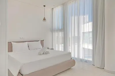 a white bedroom with a large bed and a large window at Seaview Luxury Villa Jacuzzi & Pool! 2 Min Beach in Protaras