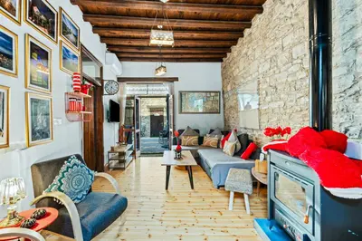 a living room with a blue couch and a stone wall at RedBlue Door Two Traditional Listed Houses in Pano Lefkara