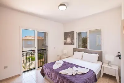 a bedroom with a bed and a balcony at Jason Villas in Protaras