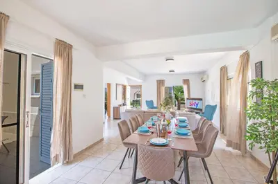 a dining room with a long table and chairs at Jason Villas in Protaras