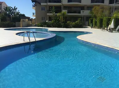 a large pool with blue water in front of a building at Pyla Gardens A102 in Pyla