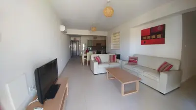 a living room with a couch and a tv at Pyla Gardens A102 in Pyla