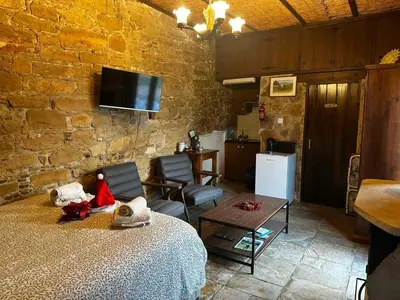 a room with a bed and a table and a tv at Pachna Studios - Village Life in Limassol