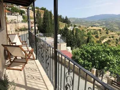 a chair sitting on the balcony of a house at Pachna Studios - Village Life in Limassol