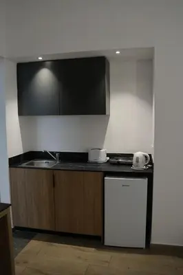 a kitchen with a sink and a counter top at Sunflower Hotel Apartments in Larnaka