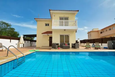 a villa with a swimming pool in front of a house at Nissi Villa Crystal in Ayia Napa