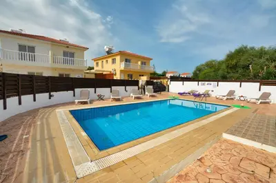 a swimming pool in front of a house at Nissi Villa Crystal in Ayia Napa