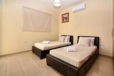 two beds in a room with a projector screen at Nissi Villa Crystal in Ayia Napa