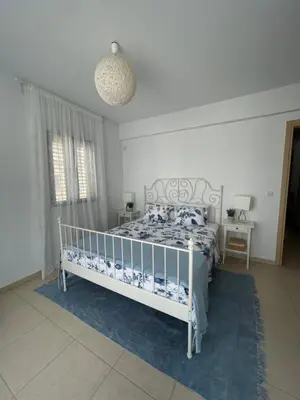 a bedroom with a white bed with a blue comforter at Indigo in Protaras