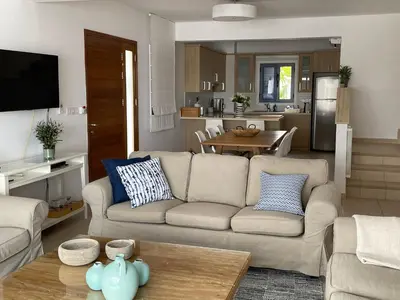 a living room with a couch and a kitchen at Indigo in Protaras