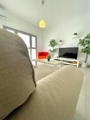 a living room with a couch and a flat screen tv at Sandy Beach Complex in Pervolia