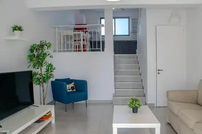 a living room with a couch and a tv at Sandy Beach Complex in Pervolia