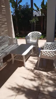three white park benches sitting on a sidewalk at ANTHORINA VILLA 9 in Protaras