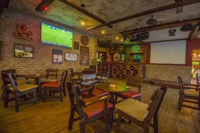 a restaurant with tables and chairs and a screen at Windmills Hotel Apartments in Protaras