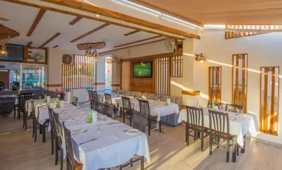 a dining room with white tables and chairs at Windmills Hotel Apartments in Protaras