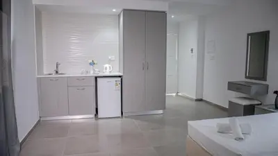 a kitchen with a sink and a white refrigerator at Windmills Hotel Apartments in Protaras