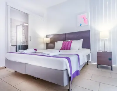 a large white bedroom with a large bed at Napian Suites in Ayia Napa
